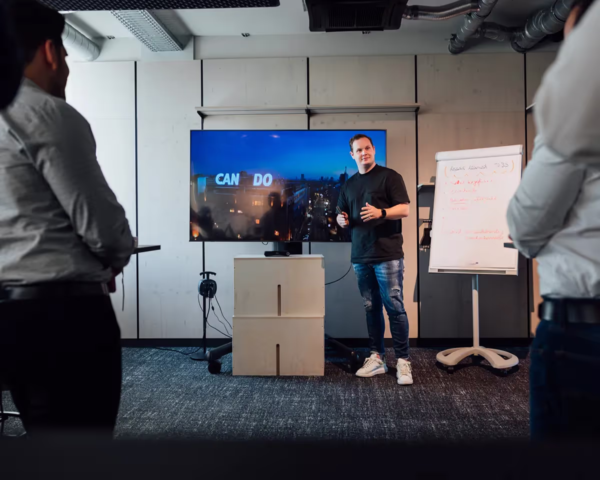Ein Mann hält eine Präsentation neben einem Flipchart