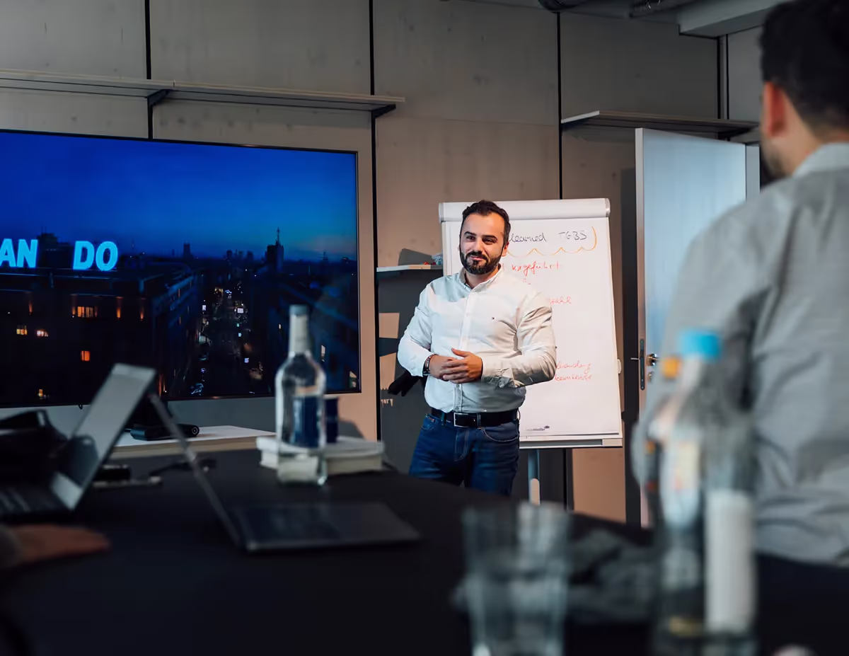 Ein Mann in einem Konferenzraum vor einem Flipchart.