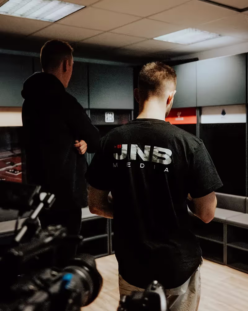 Ein paar Männer stehen nebeneinander bei einem Fernsehstudio.