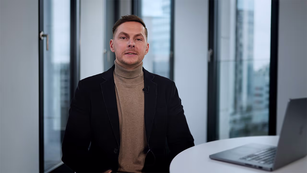 Mann sitzt an einem Tisch mit einem Laptop